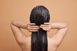 © New Africa - Woman applying hair mask on beige background, back view