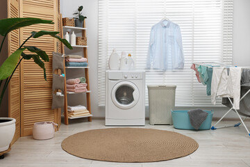 Canvas Print - Washing machine, detergents, towels, baskets and drying rack in laundry room