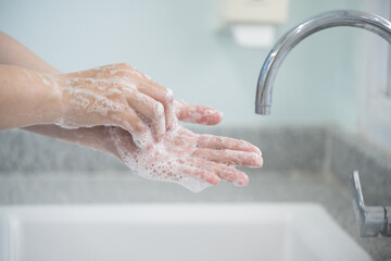 Hygiene and cleaning hands.Washing hands rubbing with soap for corona virus prevention, hygiene to stop spreading coronavirus.Close up woman hand washing in the kitchen.