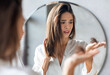 © Prostock-studio - Hairloss Concept. Worried Young Woman Holding Bunch Of Fallen Hair In Hand While Standing Near Mirror In Bathroom, Stressed Beautiful Lady Suffering Alopecia Or Health Problems, Selective Focus