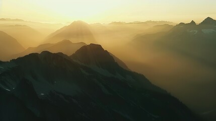 Wall Mural - Mountain Range Silhouettes at Sunset in a Misty Landscape