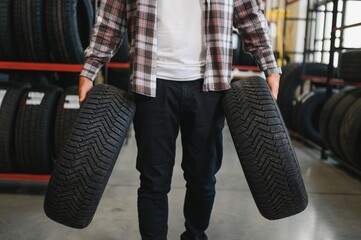 Wall Mural - Man chooses winter car tires in the auto shop