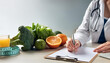 © Nira Imagens - DETALHE DAS MÃOS DE UM NUTRICIONISTA PRECREVENDO UM PLANO ALIMENTAR EM UMA MESA DE TRABALHO
