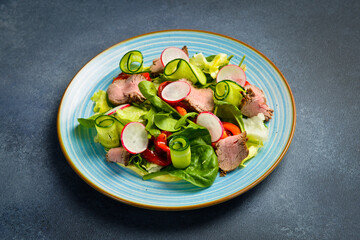 Wall Mural - Fresh vegetable salad with veal, spinach and radish. In a blue plate.