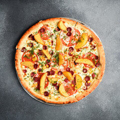 Wall Mural - Bavarian pizza with smoked sausages, tomatoes, cheese, salt and spices on a dark concrete background