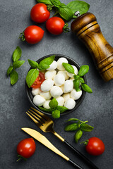 Wall Mural - Ingredients for making Caprese salad. Mozzarella cheese balls with tomatoes and basil and oil.