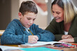 © CineLens2024/peopleimages.com - Woman, kid and homework with paper on table for learning, knowledge and support in studying. Happy, family and mother with boy in house for child development, homeschool and pride in education of son