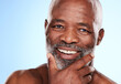 © Van Wyk/peopleimages.com - Portrait, hands and senior black man in studio for skincare, dermatology or wellness and smile. Happy, male person and healthy glow and aesthetic by blue background for retirement or morning routine