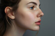 © Daniel - Side view of woman with bumpy aquiline nose in front of gray background