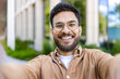 © Liubomir - Close-up of smiling man taking selfie outdoors on sunny day. Man with beard and glasses in casual clothing enjoying outdoor moment. Concept of happiness, modern communication, and casual lifestyle.