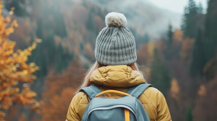 Canvas Print - A woman wearing a hat and a backpack is standing in a forest