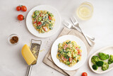 Fototapeta Pokój dzieciecy - Plates of tasty pasta with broccoli, tomatoes and cutlery on white background