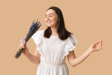 Poster - Beautiful happy young woman with bouquet of lavender flowers on beige background