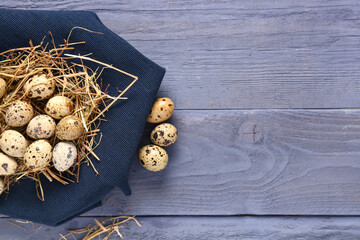 Wall Mural - Quail eggs with fabric on blue wooden background