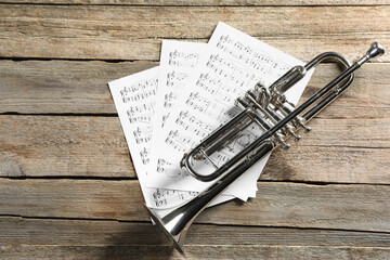 Poster - Trumpet and music sheets on wooden table, top view