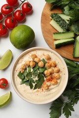 Wall Mural - Tasty hummus with chickpeas in bowl and fresh products on light table, flat lay