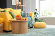 © Pixel-Shot - Wicker basket with citruses on coffee table near sofa in stylish living room