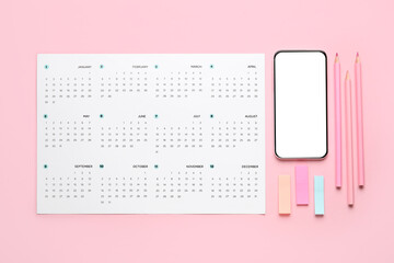 Wall Mural - Calendar with mobile phone and office stationery on pink background