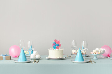 Wall Mural - Cake with sweets and dishes for birthday party on table against white wall