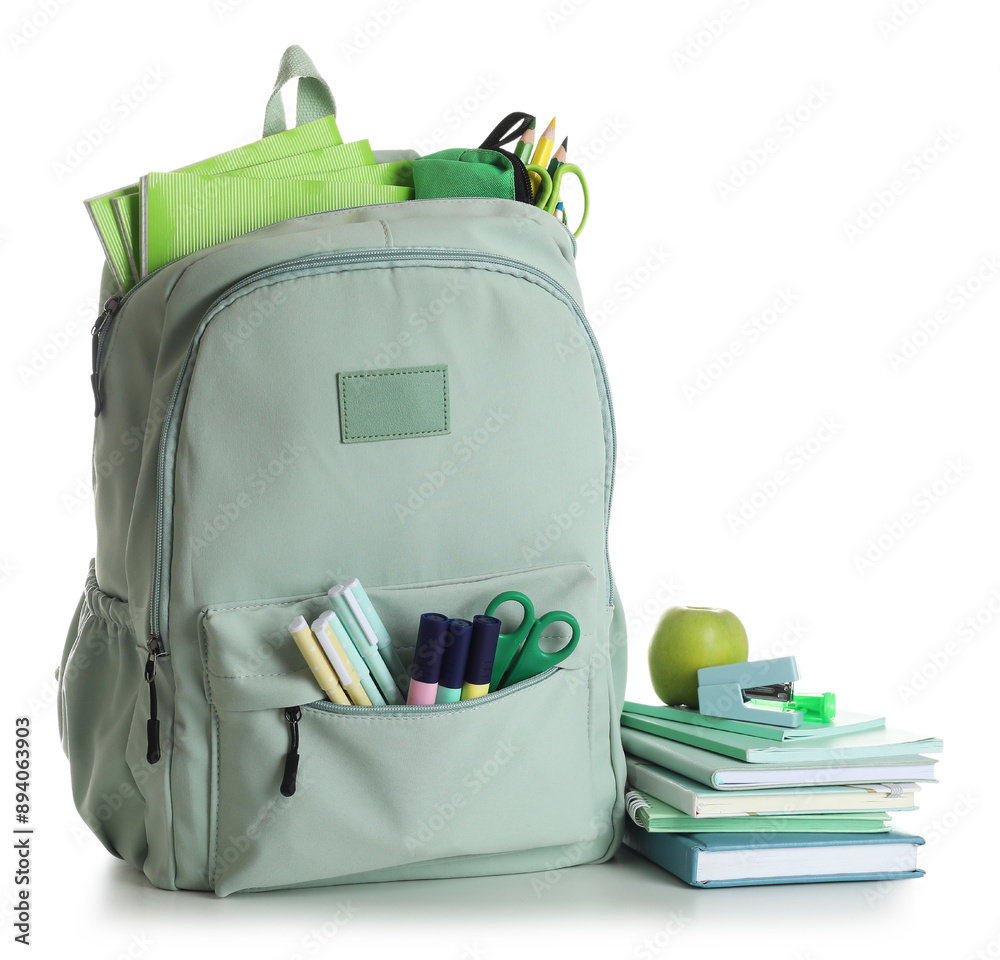 School backpack with stationery, apple and books isolated on white background