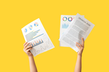 Fototapete - Female hands with documents and graphics on yellow background