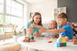 © Pixel-Shot - Cute little children with their mother sculpting from plasticine at home