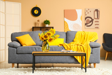 Canvas Print - Comfortable sofa and coffee table with sunflowers in interior of living room