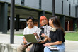 © Parichat - Diverse Group of Happy Students Studying Outdoors on Campus with Laptops and Notebooks