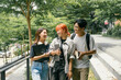 © Parichat - Group of Diverse Students Walking and Talking Outdoors on Campus with Books and Notebooks