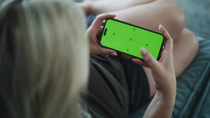Poster - back view of woman holding mobile phone with chromakey in hands and touching the screen. caucasian w