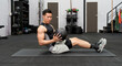 © chadchai - A man exercises with a medicine ball in a gym, focusing on core strength and muscle building.