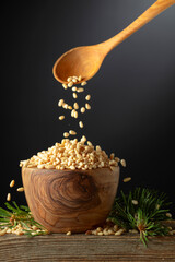 Wall Mural - Pine nuts is poured in a wooden bowl.