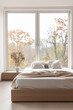 © JuanM - Modern bedroom interiors composition with a bed next to a large window and neutral colors. Apartment resting spaces with copy space.