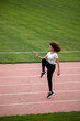 © kanashkin - Beautiful curly girl warms up on the sports ground
