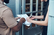 © CanBorg/peopleimages.com - Delivery, sign and woman with documents for small business, salon and barber shop products. Front door, courier service and people with signature forms for online shopping, order and collect parcel