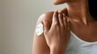 © doraclub - A close-up of a woman applying lotion on her shoulder, showcasing skincare and personal care routines for healthy skin.