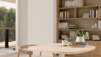 A wooden table with space to display products in a contemporary room with a large bookshelf.