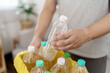 © Charlie's - Home recycle eco green zero concept Man throwing empty plastic bottle in recycling bin with yellow garbage bags at home