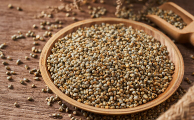 Wall Mural - closeup pile of dry bajra pearl millet seed on rustic food background in wood bowl