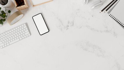 Wall Mural - A white marble tabletop workspace features a keyboard, stationery, a smartphone, and a copy space.