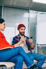 Fototapete - Group of millennial hipster students dressed in casual wear discussing website and app using modern technology and wireless internet during courses in classroom with flip chart with mock up area