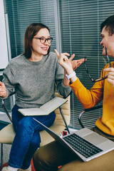 Fototapete - Positive hipster students dressed in casual wear arguing with each other having brainstorming meeting in classroom during courses.Cheerful young man and woman emotionally discussing working project
