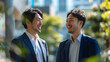 © Rossin - 笑顔で会話する2人のビジネスマン