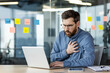 © Tetiana - Worried businessman experiencing chest pain while working on laptop in office