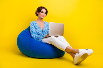 Aufkleber - Full length photo of clever optimistic girl dressed print blouse sit on pouf typing email on laptop isolated on yellow color background