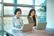 © Bojan - Two female customer service call center agents in formal business suit wearing microphone headset talking with customers at working desk in company office.