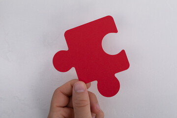 Aufkleber - A hand holds up a red puzzle piece