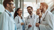 © VK Studio - A diverse group of doctors in white coats, sharing a hearty laugh inside a brightly lit hospital.
