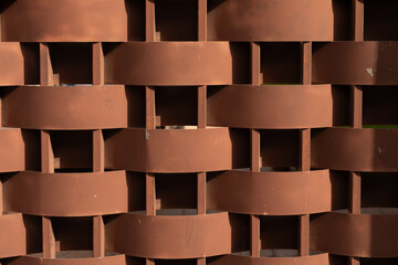 Poster - A woven metal wall with a rusty brown hue