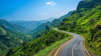 Poster - A winding mountain road snaking through lush green hillsides under a clear blue sky, perfect for scenic drives.